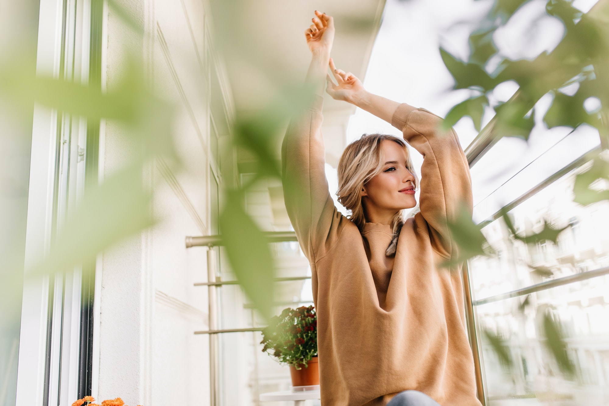 Gorgeous white girl posing near green plant. Photo of smiling magnificent woman with blonde hair